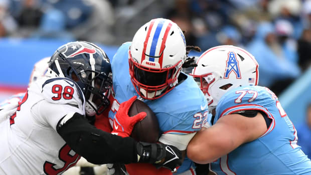 Titans running back Derrick Henry is tackled by Houston Texans defensive tackle Sheldon Rankins (98) during the second half at Nissan Stadium.